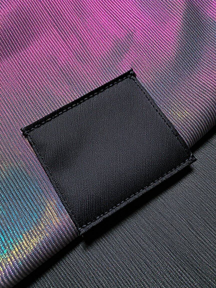 Plain black woven label stitched onto iridescent lenticular fabric