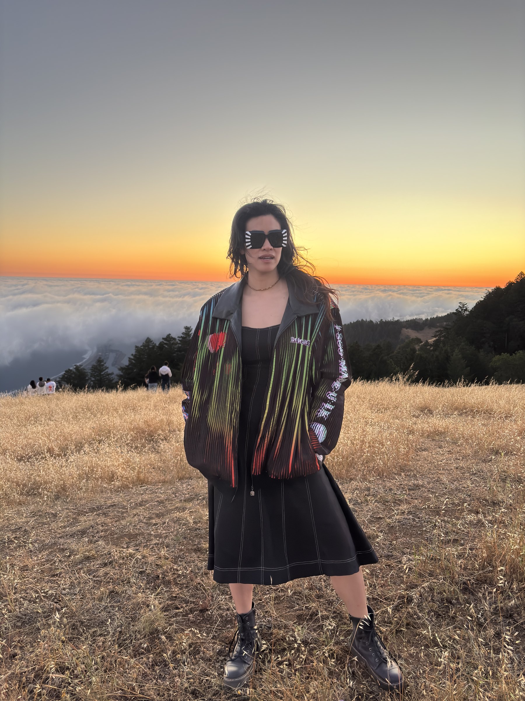 A customer wearing the Love is the Message lenticular jacket on Mt. Tamalpais at golden hour